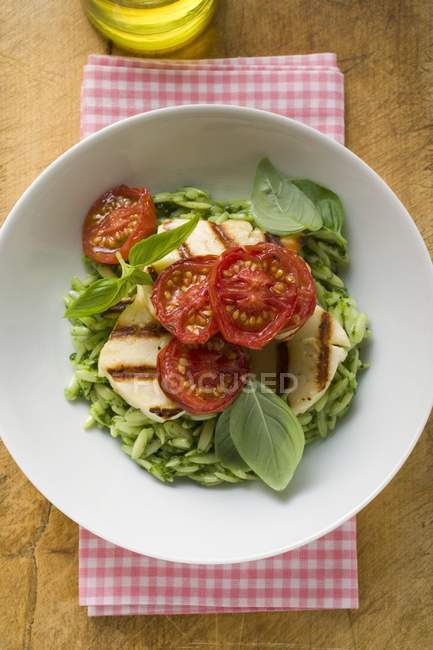 Green risoni pasta with pesto and tomatoes — Stock Photo