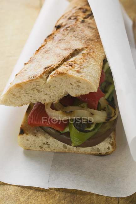 Baguette with grilled vegetables on paper — Stock Photo
