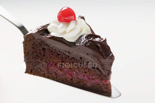 Pastel de chocolate con crema y cereza - foto de stock