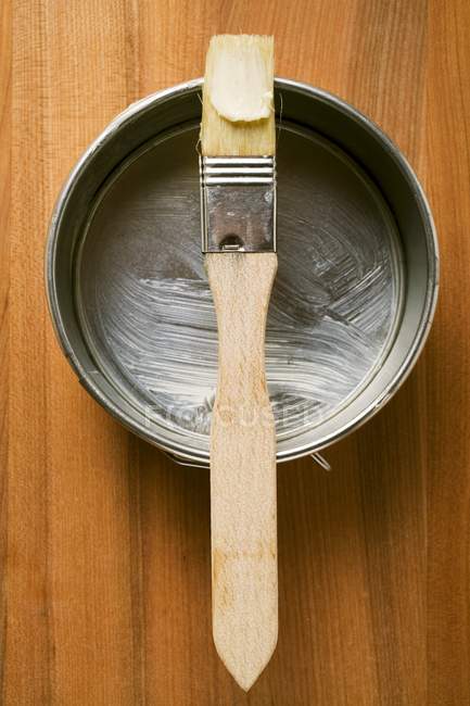 Vista superior del cepillo de pastelería con mantequilla en la bandeja para hornear - foto de stock