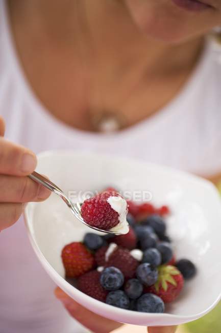 Woman eating berries with yoghurt — Stock Photo