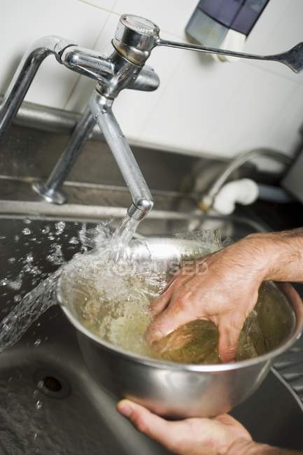 Обрезанный вид рук, впитывающих желатин в воду — стоковое фото