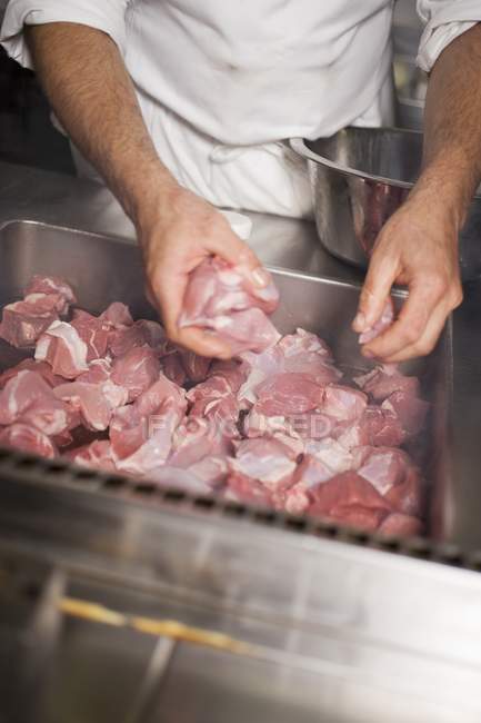 Koch legt Schweinefleisch in Bratenform — Stockfoto