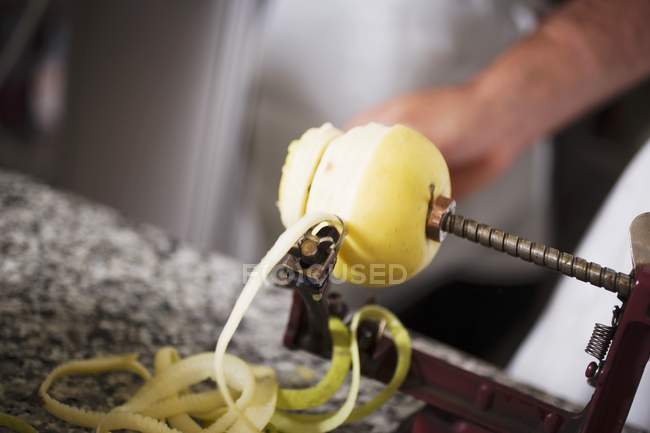 Closeup view of peeling an apple and cutting into a spiral — Stock Photo