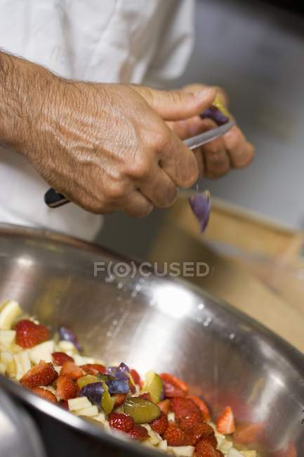 Крупный план обрезания вид человека, рубящего фрукты — стоковое фото
