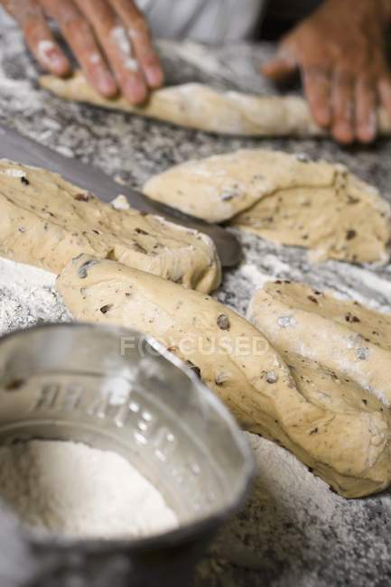 Руки, делающие оливковый хлеб — стоковое фото