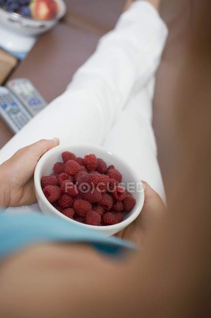 Mulher comendo framboesas frescas — Fotografia de Stock