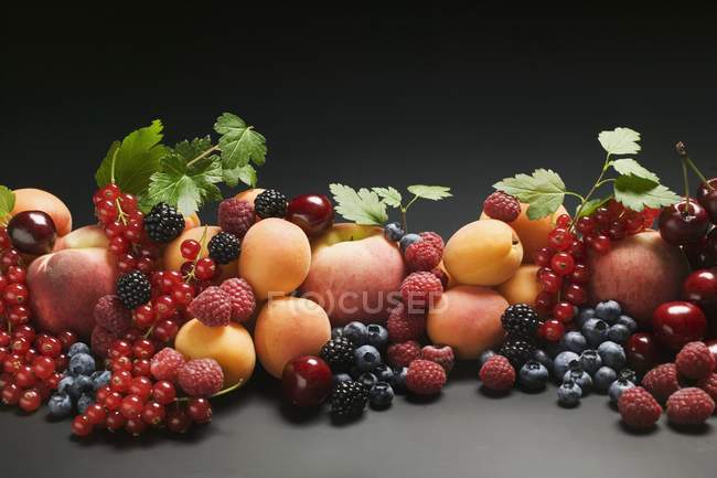 Peaches with apricots and mixed berries — Stock Photo
