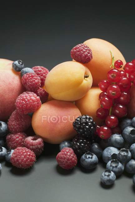 Персики з абрикосами і змішаними ягодами — стокове фото