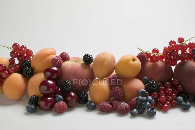 Абрикосы с персиками и смешанными ягодами — стоковое фото