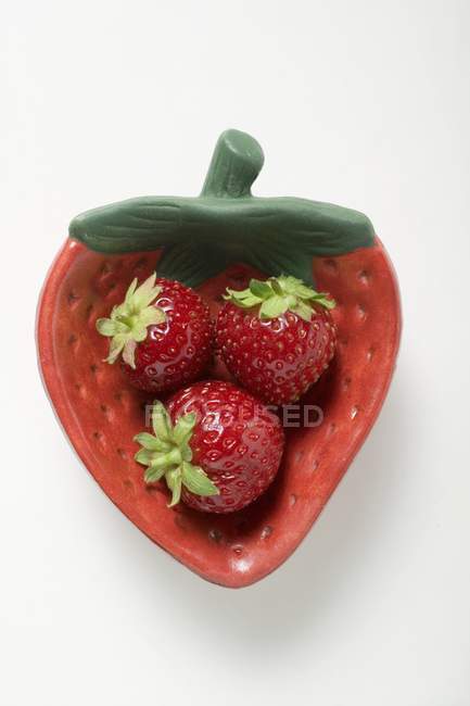 Strawberries in strawberry-shaped dish — Stock Photo