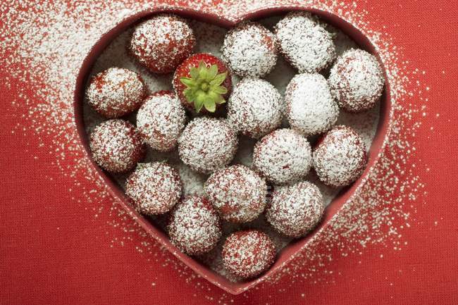 Morangos com açúcar no prato em forma de coração — Fotografia de Stock