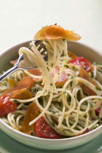 Спагетти с брезаолой и помидорами — стоковое фото