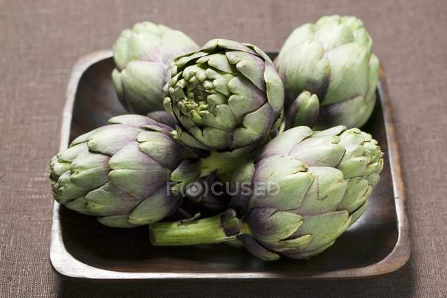 Fresh artichokes in bowl — Stock Photo