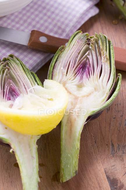 Alcachofra cortada pela metade com fatia de limão — Fotografia de Stock