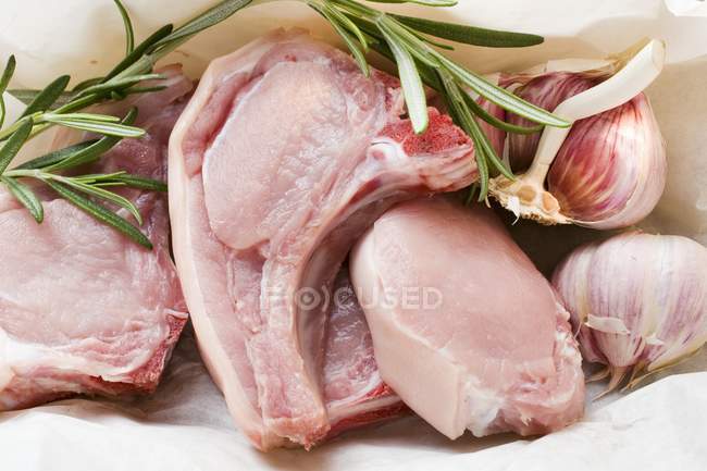 Raw pork chops with rosemary and garlic — Stock Photo