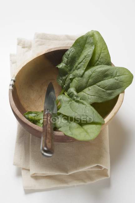 Spinach leaves in wooden bowl — Stock Photo