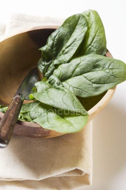 Foglie di spinaci in ciotola di legno — Foto stock