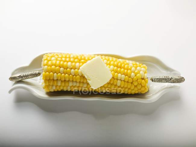 Кукуруза на початке с ручкой масла — стоковое фото