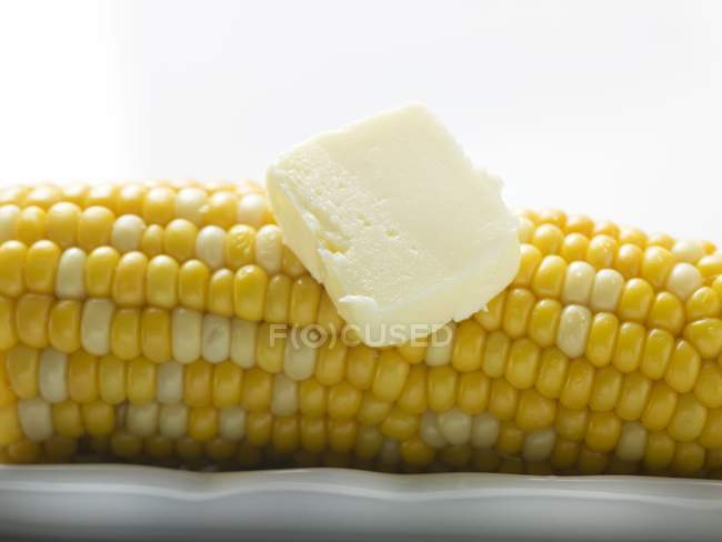 Épi de maïs avec bouton de beurre — Photo de stock