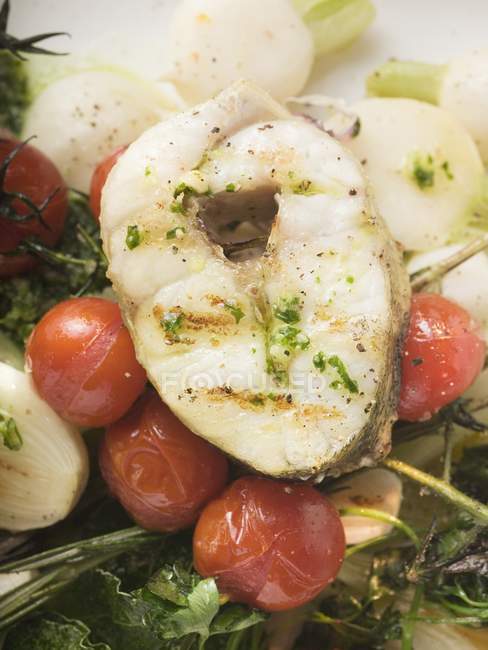 Grilled sea bass cutlet on roasted cherry tomatoes — Stock Photo
