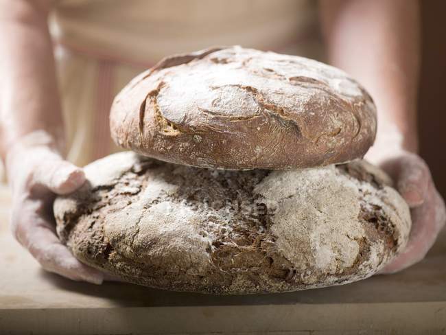 Mãos humanas segurando pães — Fotografia de Stock