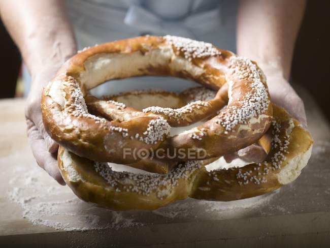 Woman holding soft pretzels — Stock Photo