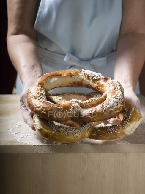 Mulher segurando pretzels macios — Fotografia de Stock