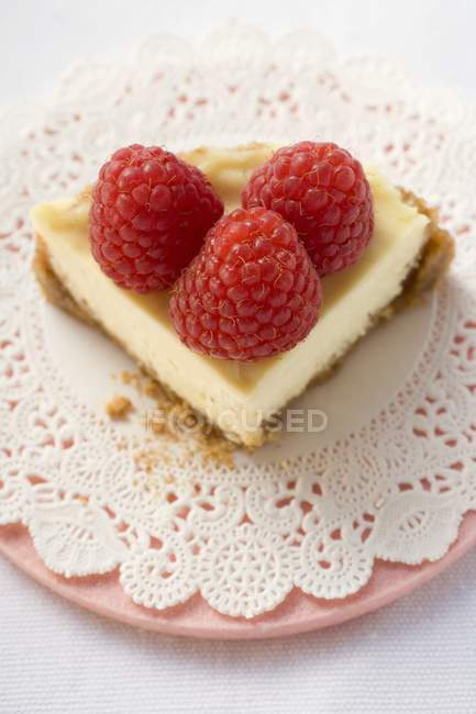 Piece of cheesecake with raspberries — Stock Photo