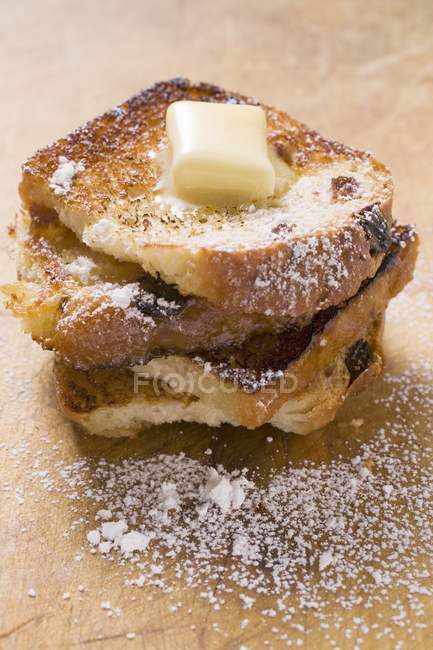 Closeup view of French toasts with knob of butter and icing sugar — Stock Photo