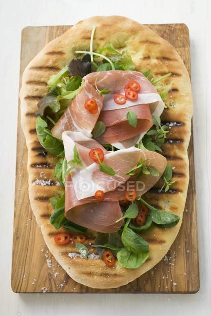 Prosciutto di Parma ed erbe aromatiche sul pane della pizza — Foto stock