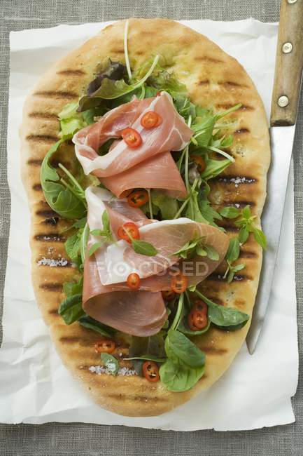 Parma ham and herbs on pizza bread — Stock Photo