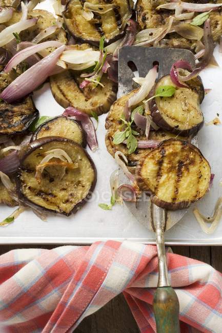 Grilled aubergines with onions on tray with server — Stock Photo