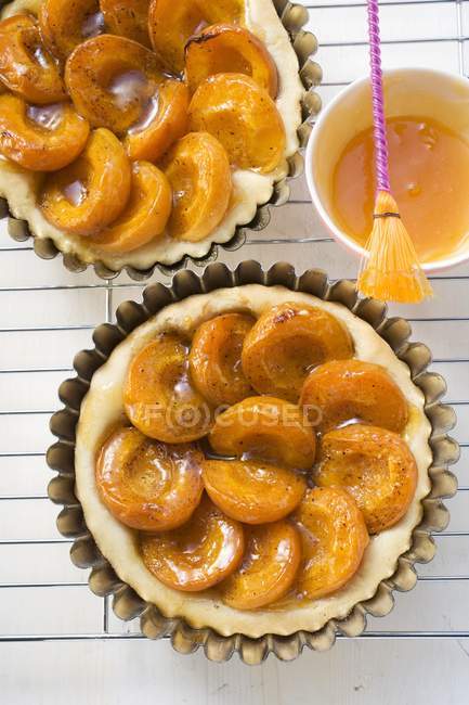 Apricot tarts in baking tins — Stock Photo