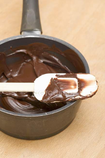 Geschmolzene Schokolade auf Spachtel und in Pfanne — Stockfoto