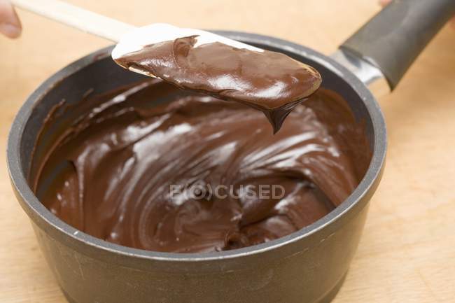 Chocolate derretido na espátula e na panela — Fotografia de Stock