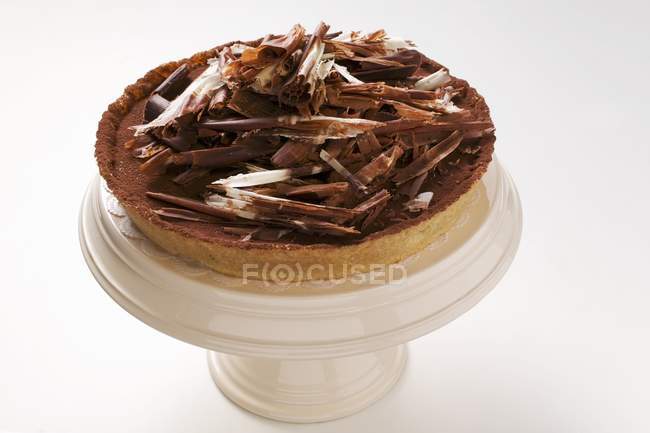 Whole chocolate tart with chocolate curls — Stock Photo