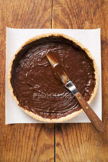 Top view of spreading pastry case with chocolate — Stock Photo