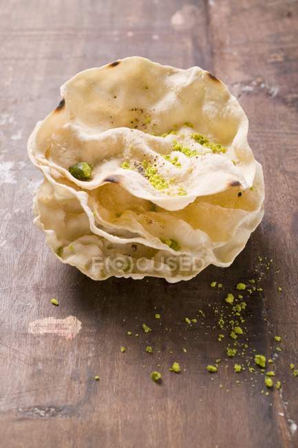 Poppadams with grated pistachios — Stock Photo