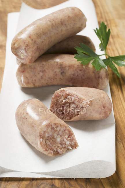 Closeup view of Salsiccia sausages on paper with herb — Stock Photo