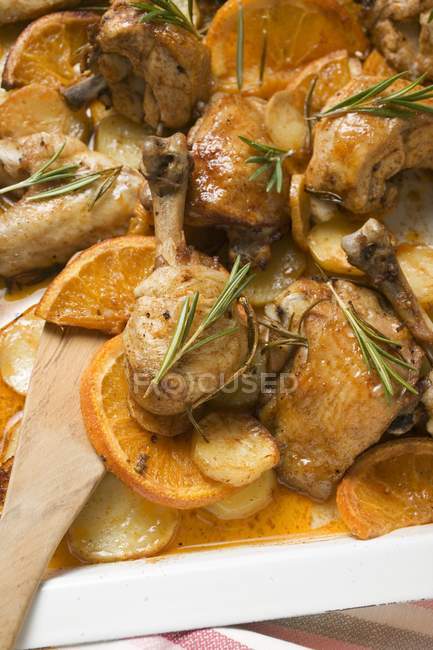 Trozos de pollo asado con naranjas y romero - foto de stock