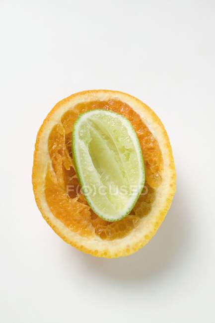 Squeezed lime inside squeezed orange — Stock Photo