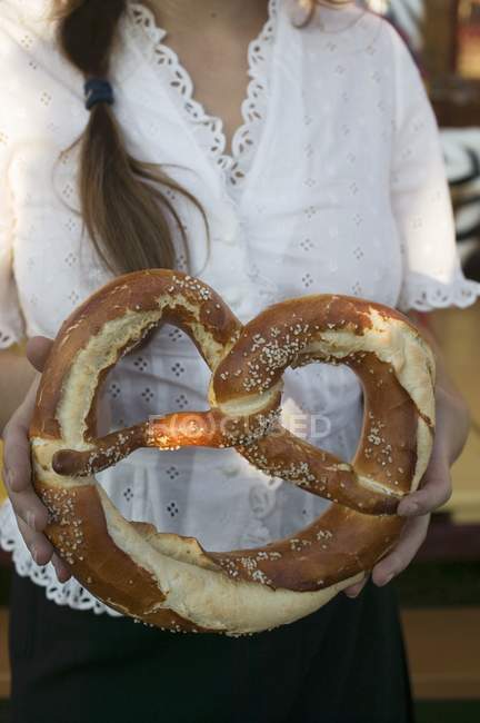 Donna in possesso di pretzel gigante — Foto stock
