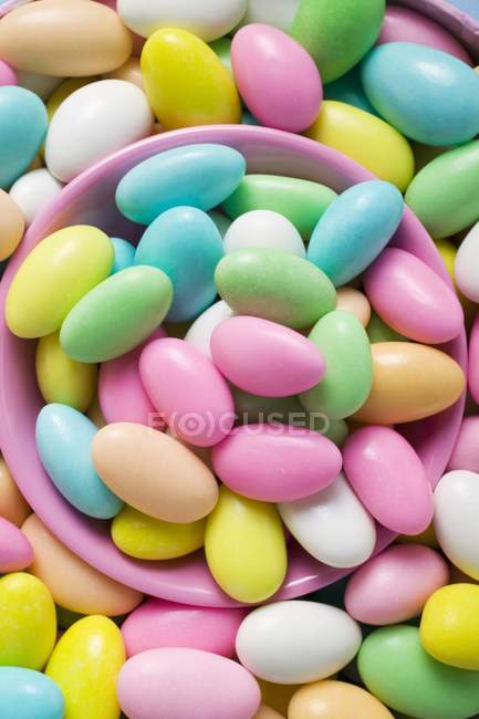 Sugared almonds with pink bowl — Stock Photo