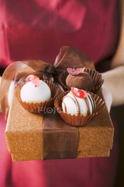 Mujer ofreciendo chocolates - foto de stock