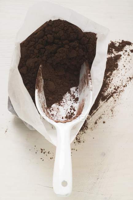Cocoa powder in bag with scoop — Stock Photo