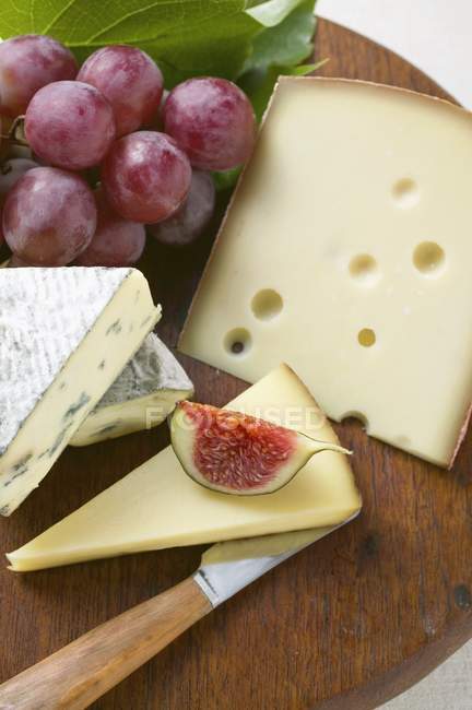 Tabla de quesos con higo y uvas - foto de stock