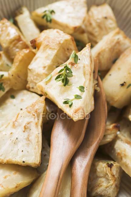 Roasted chunks of celeriac in dish with wooden forks — Stock Photo