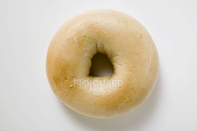 Fresh bagel on white surface — Stock Photo