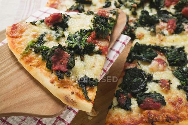 Pizza con fetta sul server — Foto stock